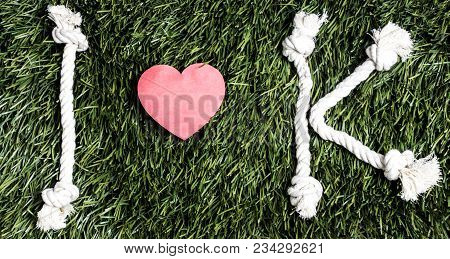 I And K Letters And Three Paper Heart Cut Outs On Grass