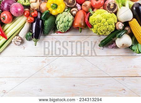 Different colorful vegetables arranged as a frame. Organic food. Wooden background.