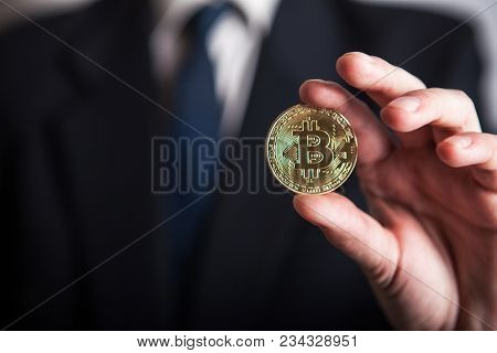 Golden Bitcoin In A Man Hand, Digitall Symbol Of A New Virtual Currency. Man Recived Money From Bitc