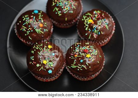 Homebaked Chocolate Muffins For Easter With Colored Conffeti. Dark Background. Sweet Dessert