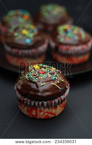 Homebaked Chocolate Muffins For Easter With Colored Conffeti. Dark Background. Sweet Dessert