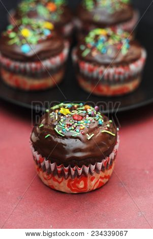 Homebaked Chocolate Muffins For Easter With Colored Conffeti. Dark Background. Sweet Dessert