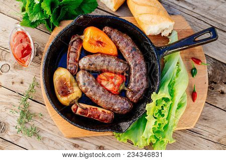 Oktoberfest. Assorted Different Grilled Sausages On A Wooden Table. Fried Sausages On A Cast-iron Fr