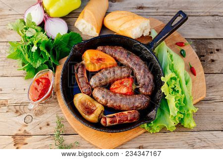 Oktoberfest. Assorted Different Grilled Sausages On A Wooden Table. Fried Sausages On A Cast-iron Fr