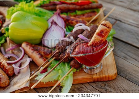 Oktoberfest. Assorted Different Grilled Sausages On A Wooden Table. Fried Sausages On A Cast-iron Fr