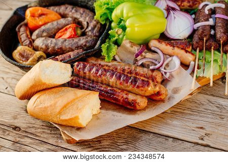 Oktoberfest. Assorted Different Grilled Sausages On A Wooden Table. Fried Sausages On A Cast-iron Fr