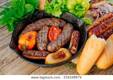 Oktoberfest. Assorted Different Grilled Sausages On A Wooden Table. Fried Sausages On A Cast-iron Fr