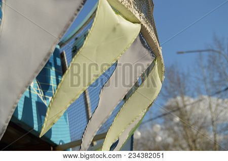 Close-up, Selective Focus, Wind Slaps Garlands Of Colorful Flags Against Blue Sky, Park In Spring.