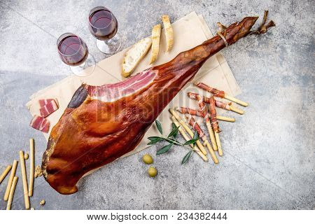 Whole Leg Ham Jamon Serrano And Red Wine On Gray Background. Top View. Flat Lay.