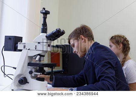 ST. PETERSBURG, RUSSIA - OCTOBER 16, 2017: Schoolchild at microscope in a classroom of the physics and mathematics lyceum 366. This year lyceum celebrates its 70th anniversary