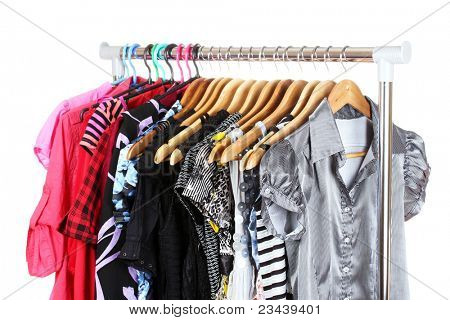 เสื้อผ้าที่แตกต่างกันบน hangers แยกต่างหากบนพื้นสีขาว