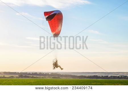 Flight On A Motor Glider In The Blue Sky With Bright Backlight Sunlight Over The Green Plain. Solar 