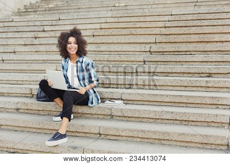 Smiling African-american Student Girl Sitting On Stairs Working With Laptop, Preparing For Exams Out