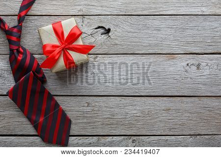 Happy Fathers Day Card With Copy Space, Present And Red And Black Striped Necktie On Rustic Wood Bac