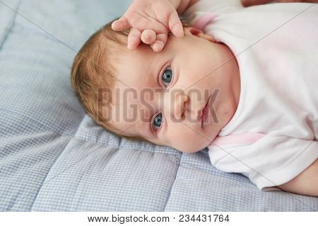 Beautiful Baby On Back On Blue Bed
