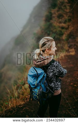 Close Up Of Woman Hiker With Blue Backpack On The Narrow Misty Path Of Mountain Ridge On Santo Antao