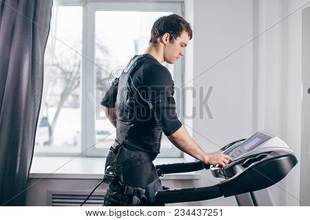 Fit Man In Black Electric Muscle Stimulation Suit For Ems Training Running On Treadmill At Gym