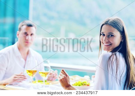 happy young couple having lanch at beautiful restaurant on by the sea on  beach