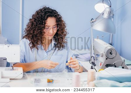 Caucasian Tailor Stretching Thread At Sewing Workshop, Taking Up Sewing