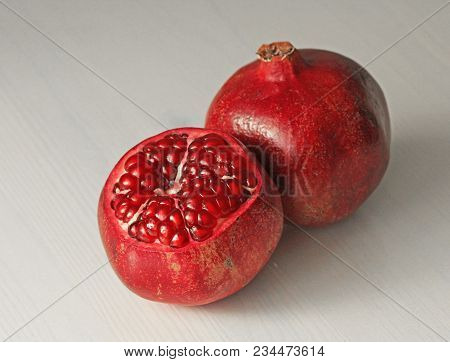Big Ripe Red Granets Or Garnets. Fruits Of Red Ripe Pomegranate On The White Background. Vegetarian 