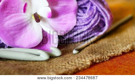 Hooks For Knitting, Purple Yarn, And A Beautiful Orchid