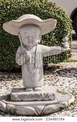 Hacienda Heights, Ca, Usa - March 23, 2018: Closeup Of Boy Novice Monk Cement Statue In Garden Of Hs