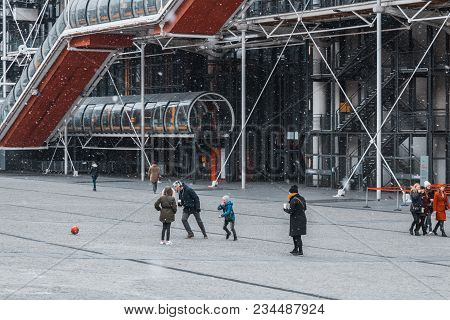 Paris, France - Feb 27,2018:  Father With Children Playing Ball Near Center Of Pompidou In Winter Da