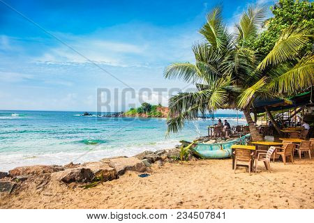 Mirissa Beach, Sri Lanka - JAN 2, 2017:  Tourists walking on the sand while enjoying the view across the wonderful beach of Mirissa on Jan 2, 2017. Sri Lanka.