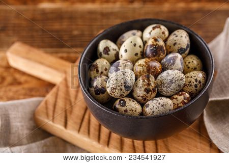 Quail Eggs In Ceramic Mug, Napkin, Wooden Board On Wooden Table. Quail Eggs Similar In Color With A 