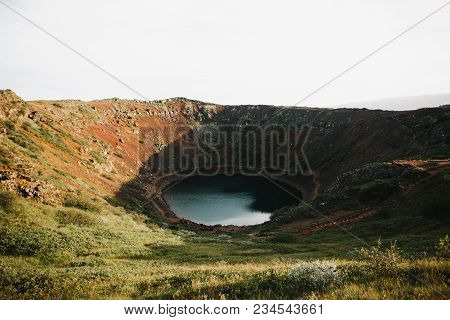 Beautiful Kerid Volcanic Lake And Green Vegetation On Rocky Hills In Iceland