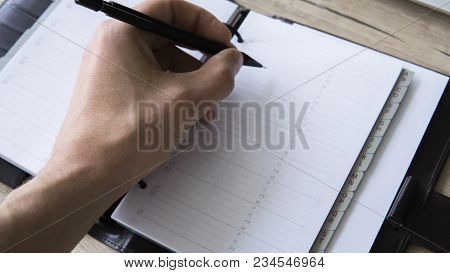 Man Is Going To Write Something On His Notebook. Top View, Flat Lay. In Search Of Inspiration. A Man