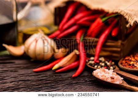 Wooden Spoons With Dried Ginger, Peppercorn, Salt, Garlic, Oil, Balsamic Vinegar, And Red Chili Pepp