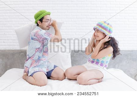 Couple Asian Man And Woman With Woolhat Together Funny Moment On White Bed