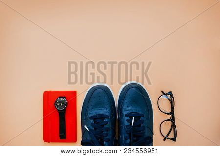 Flatlay With Casual Style Dark Blue Leather Sneakers, Clear Lens Glasses, Red Notebook And Black Dia