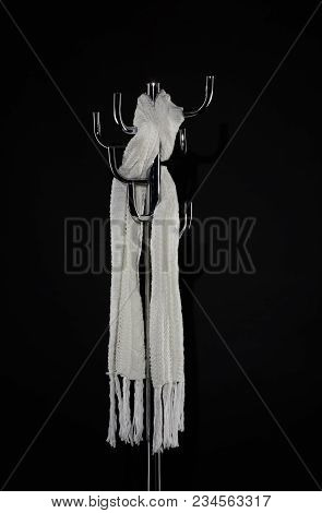 White Scarf Hanging On Coat Rack Isolated On Black