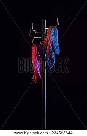Scarf Hanging On Coat Rack Under Toned Light Isolated On Black