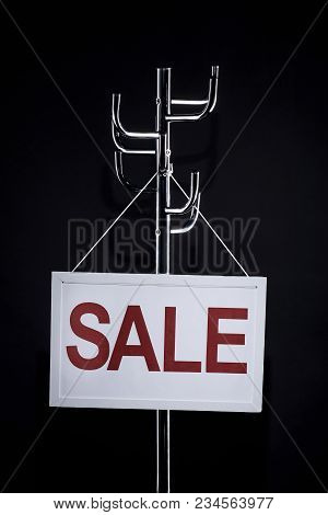 Sale Signboard Hanging On Coat Rack Isolated On Black
