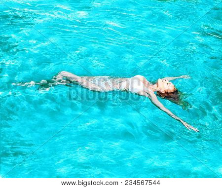 Beautiful Girl Swimming On Back In Water