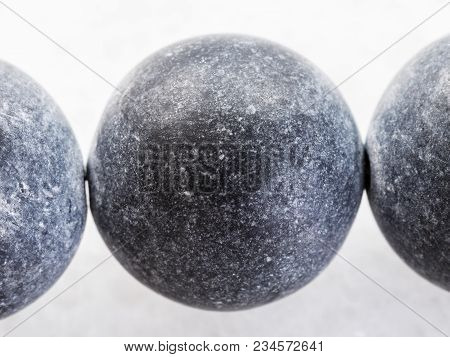 Macro Shooting Of Natural Mineral Rock Specimen - Necklace From Shungite Gemstone On Dark Granite Ba