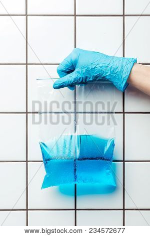 Cropped Image Of Woman In Blue Rubber Glove Holding Ziplock Plastic Bag With Water, Earth Day Concep