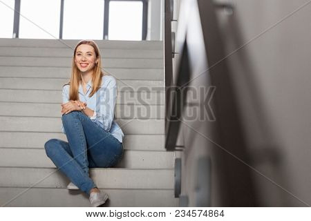 people, business and education concept - happy smiling woman or student sitting on stairs