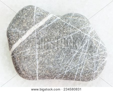Macro Shooting Of Natural Mineral Rock Specimen - Pebble Of Greywacke Sandstone On White Marble Back