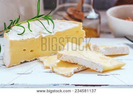 Cheese Plate Served With Crackers, Honey And Nuts. Camembert On White Wood Serving Board Over White 