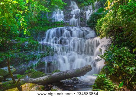 Mun Dang Waterfall With A Pink Flower Foreground In Rain Forest At Phitsanulok Province, Thailand