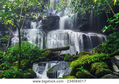 Mun Dang Waterfall With A Pink Flower Foreground In Rain Forest At Phitsanulok Province, Thailand