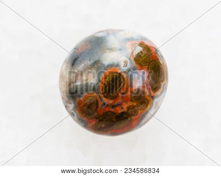 Macro Shooting Of Natural Mineral Rock Specimen - Polished Orbicular Jasper Gemstone On White Marble