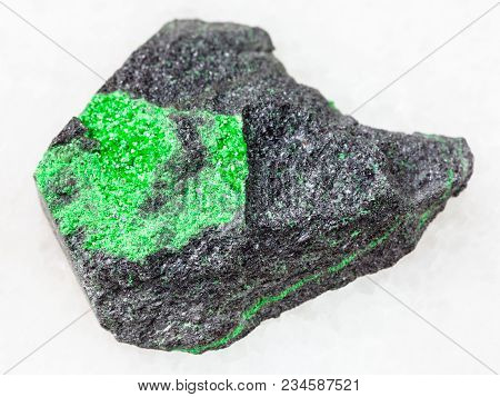 Macro Shooting Of Natural Mineral Stone Specimen - Uvarovite Crystals On Rough Rock On White Marble 