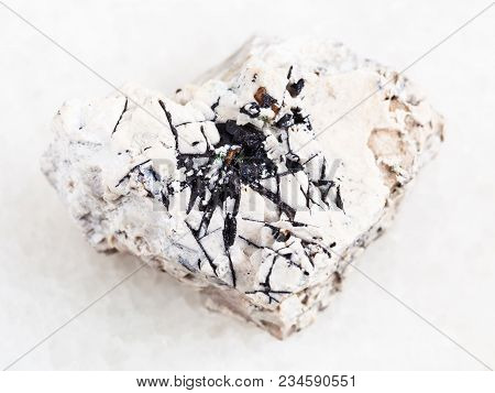Macro Shooting Of Natural Mineral Rock Specimen - Ilmenite Black Crystals On Raw Stone On White Marb
