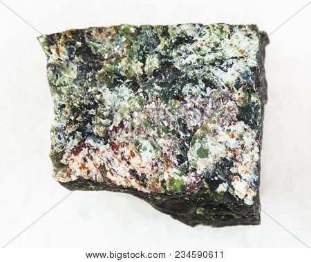 Macro Shooting Of Natural Mineral Rock Specimen - Rough Dunite Stone On White Marble Background