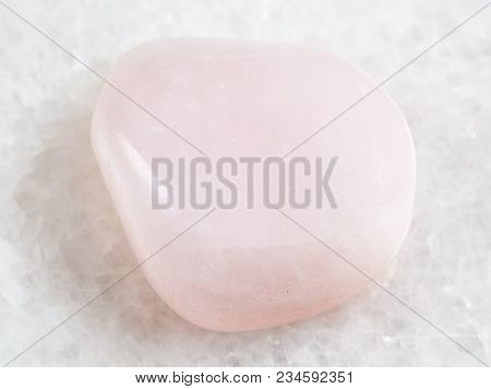 Macro Shooting Of Natural Mineral Rock Specimen - Tumbled Pink Petalite Gemstone On White Marble Bac